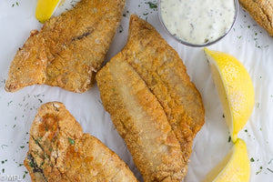 air fried fish on parchment paper with lemon slices